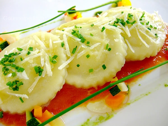 Raviolis de patata rellenos de jamón y de puerros sobre crema de tomate