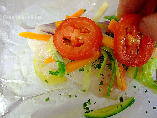 Das Petersfischfilet mit blanchierten Gemüse, Tomaten und Gewürzen