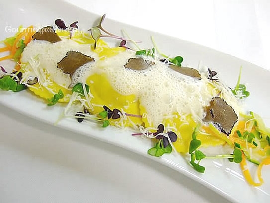 Ravioli fatti in casa ripieni di tartufo su verdure sauté