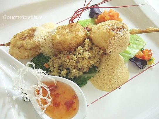 Brochette aux coquilles Saint-Jacques en pâte "tempura" à frire sur couscous aux légumes à la sauce au homard