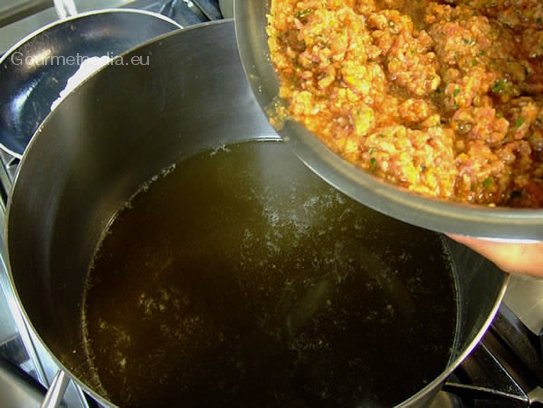 Die Eiswürfel mit der Gemüse-Fleischfüllung vermischen und die Klärmasse in das kalte Consommé einrühren