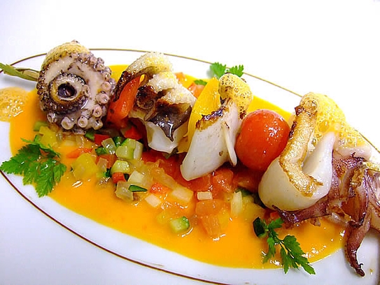 Brochette of calamaries, cuttlefish and octopus on peppersauce with vegetable ragout