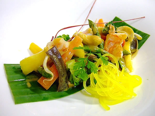 Légumes au curry rouge avec crevettes, ananas à la cayenne et lait de coco dans une feuille de bananier