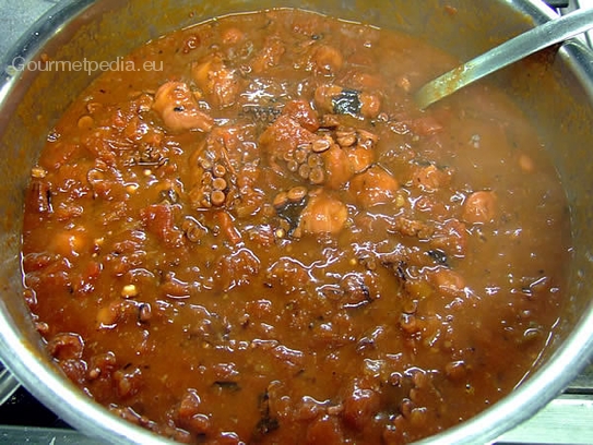 Den Octopus in der leicht scharfen Tomatensauce langsam kochen lassen