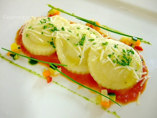 Raviolis de pommes de terre au jambon et poireaux sur la crème de tomates