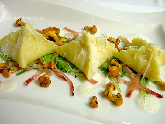 Raviolis de pommes de terre farcis aux chanterelles sur lit de poireaux sautés et petits lardons