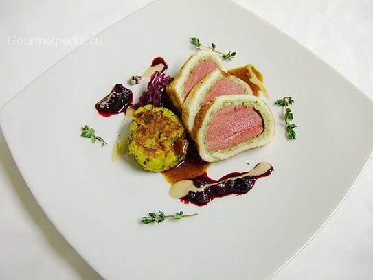 Fillet of venison in a crisp bread crust on yellow boletus sauce with cranberries