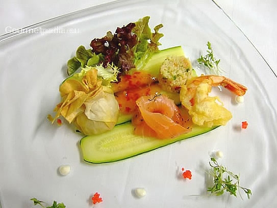 A variety of fish on a bed of zucchinis with marinated salads
