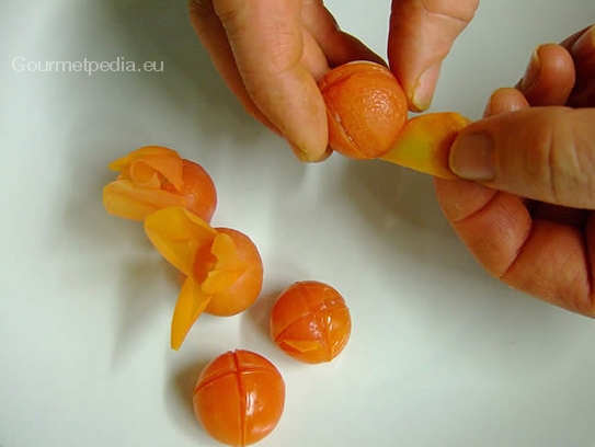 Die teils abgelöste Tomatenschale von dem Einschnitt Richtung gegenüberliegende Seite ziehen