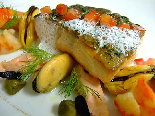 Grilled salmon steak with seafood with white wine sauce