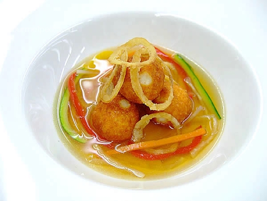 Essence of chicken with cheese praliné, onion rings and vegetable julienne