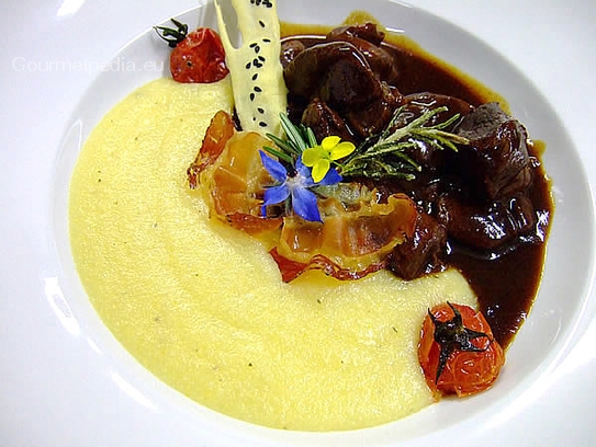 Würziges Hirschgulasch an cremiger Thymianpolenta mit knusprigen Bauchspeck-Chips