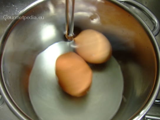 Die Eier aus dem Kochwasser nehmen und unter kalten fließenden Wasser abkühlen