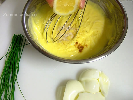 Zitronensaft und Gewürze in die Eiersauce einrühren