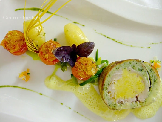 Rollito de bacalao fresco albardado en tocino con espinacas y azafrán albardado en tocino con tomatitos gratinados
