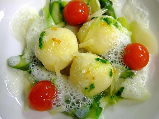 Gnocchi di patate ripieni al formaggio su asparagi verdi e bianchi sauté