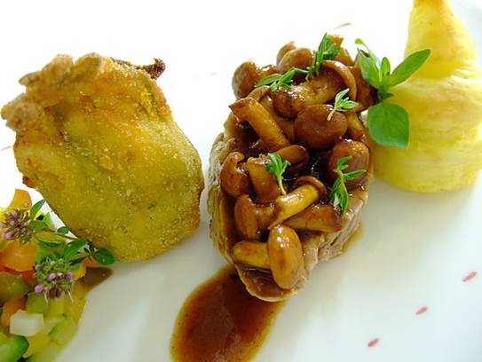 Medallion of veal with chanterelle sauce, sauteed vegetables and fried squash blossom
