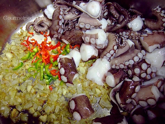 Die Octopusstücke in den Topf zu den Zwiebeln geben