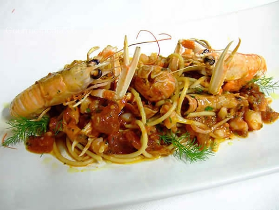 Espaguetis (pasta) con salsa de tomate y cigalas