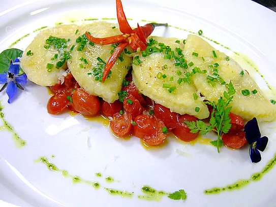 Kartoffelravioli mit Schinken-Lauchquarkfüllung auf geschmolzenen Datteltomaten, Butter und Parmesan