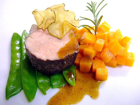 In red wine and herbs poached fillet of veal on pumpkin ragout and glazed sugar peas