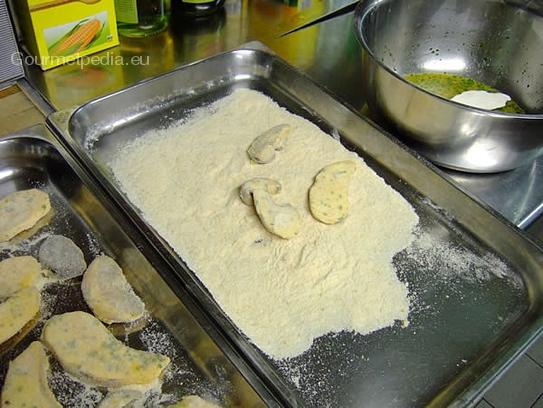 Die Steinpilzscheiben in den Brotbröseln panieren