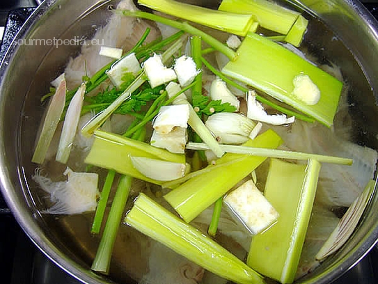 Die Fischabfälle in Wasser mit Gewürzen und Gemüse zum Kochen bringen