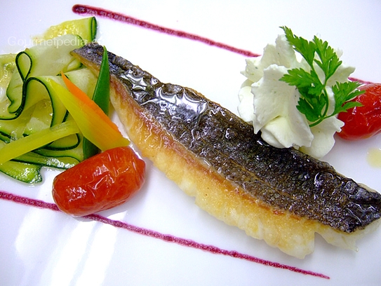 Grilled sea bass fillet on marinated courgettes salad with garlic foam